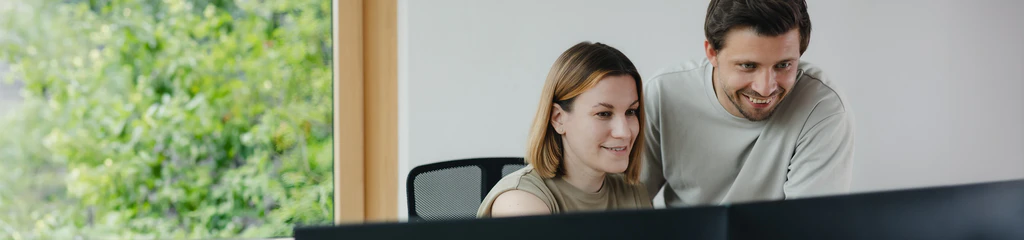 Mitarbeiter der Qualitätssicherung schauen zusammen auf den Computer