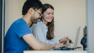 Mitarbeiter schauen zusammen auf den Laptop
