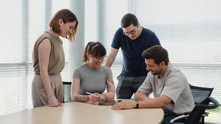 Mitarbeiter der Qualitätssicherung arbeiten gemeinsam am Tablet