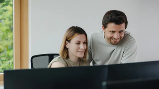Mitarbeiter der Qualitätssicherung schauen zusammen auf den Computer