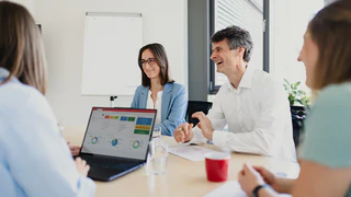 Mitarbeiter des Sales besprechen sich im Büro