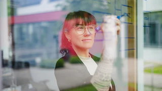 Mitarbeiterin des Produktmanagements schreibt an das Fenster