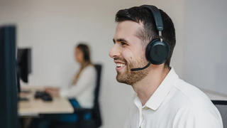 Mitarbeiter des Customer Supports sitzt vor Computer