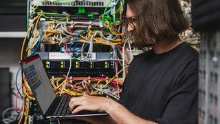Mitarbeiter der IT arbeitet am Laptop