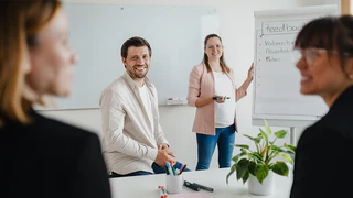 Personengruppe bei Feedbackrunde an Flipchart