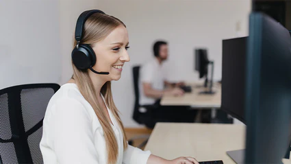 Mitarbeiterin des Customer Supports sitzt vor Computer