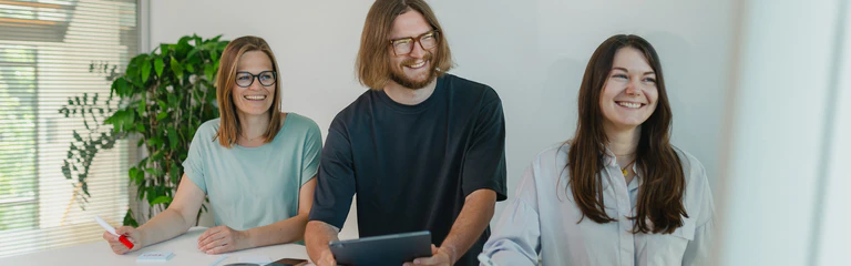 Mitarbeiter in der Softwareentwicklung lächeln und arbeiten am Tablet