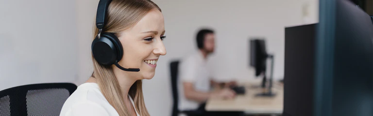 Mitarbeiterin des Customer Supports sitzt vor Computer