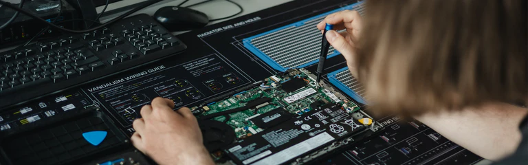 Mitarbeiter der IT bestückt elektronische Bauteile auf einer Platine