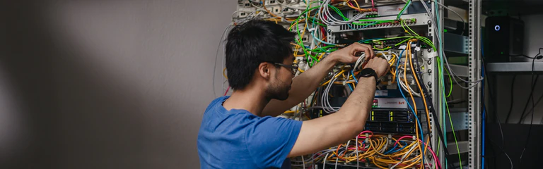 Mitarbeiter der IT steckt Kabel an